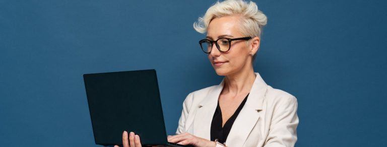 mulher branca de cabelos grisalhos segurando um notebook