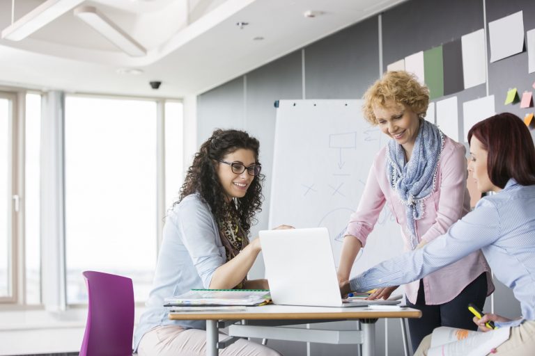 profissionais de RH discutindo qual sistema de gestão de RH escolher