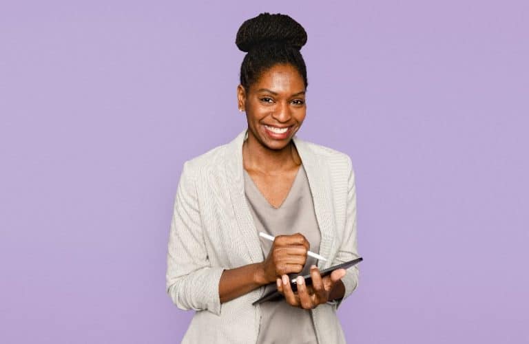 mulher negra sorrindo segurando um tablet