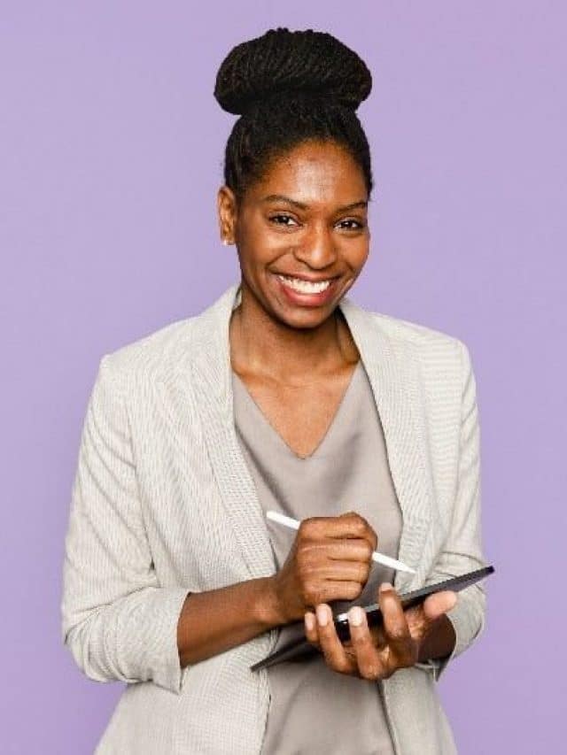 mulher negra sorrindo segurando um tablet