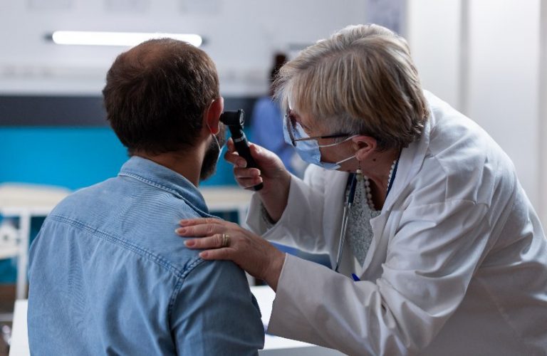 otorrinolaringologista examinando o ouvido de um paciente