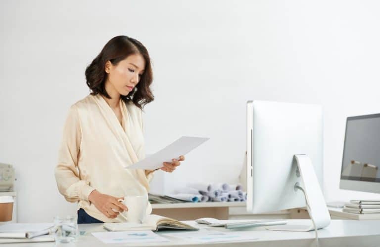 mulher asiática analisando um documento em seu escritório
