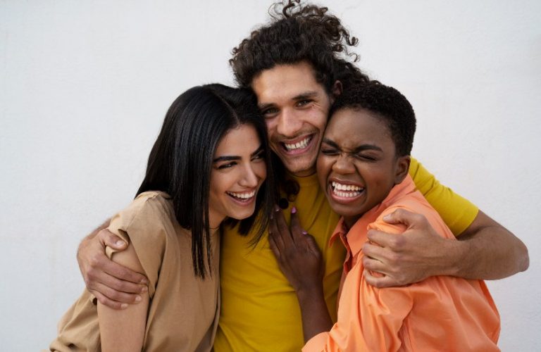 três pessoas multiétnicas se abraçando