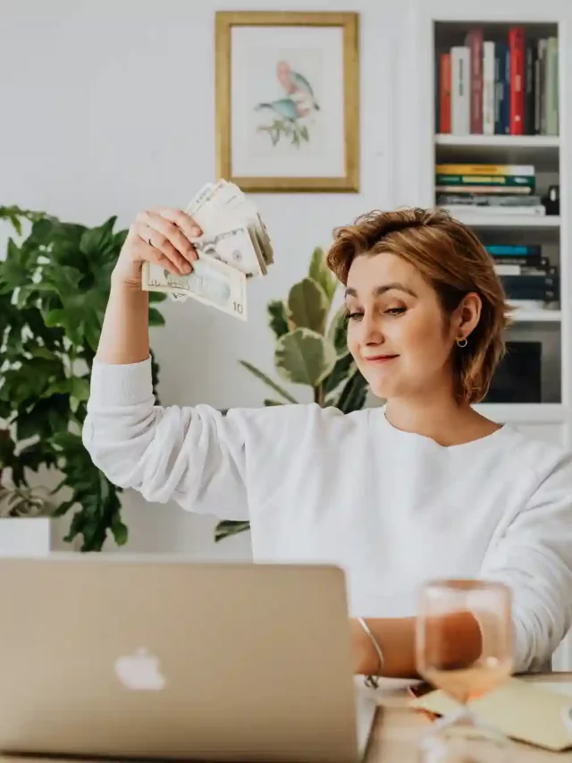 mulher branca segurando notas de dinheiro