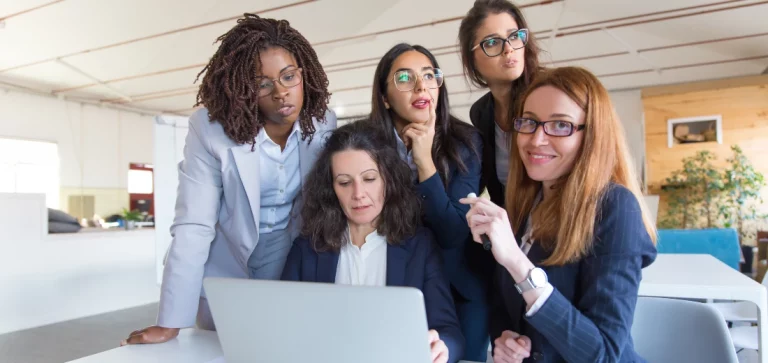 Mulheres sorrindo olhando para a tela do computador