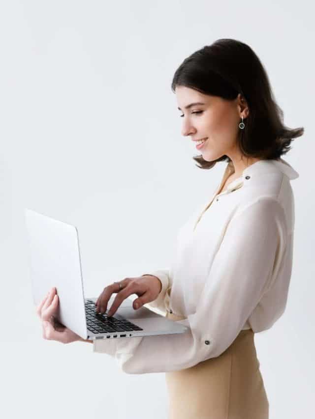 mulher branca segurando um laptop