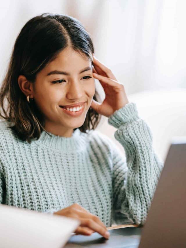 mulher sorrindo olhando para um notebook