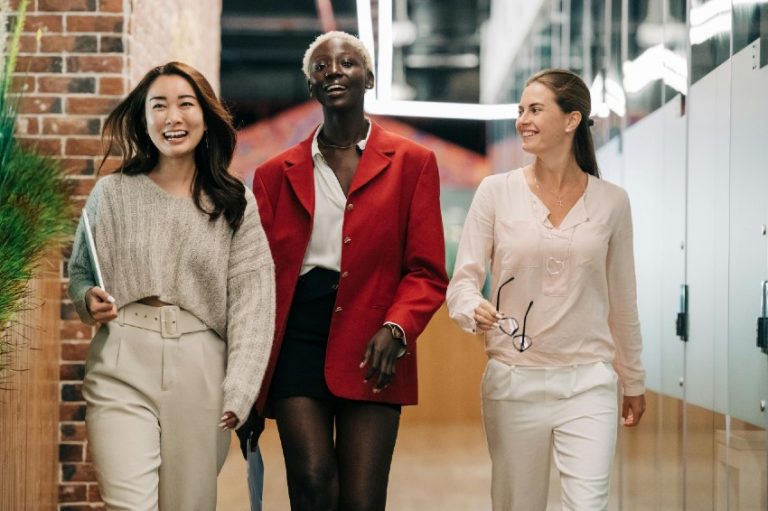 03 mulheres andando na empresa sorrindo.